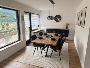 a dining room with a wooden table and chairs at Ferienwohnung Bächle in Bad Peterstal