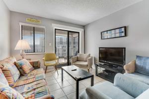 a living room with a couch and a tv at Plantation East #2314 in Gulf Shores