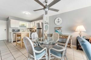 a dining room and kitchen with a glass table and chairs at Plantation East #2314 in Gulf Shores