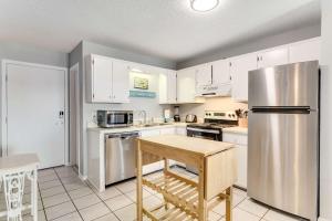 a kitchen with white cabinets and a stainless steel refrigerator at Plantation East #2314 in Gulf Shores +52 photos