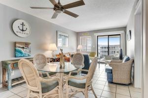 a dining room and living room with a table and chairs at Plantation East #2314 in Gulf Shores