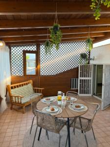 a patio with a table and chairs on a porch at SvEly House B&B in Campomarino