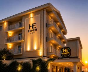 a hotel with a sign on the side of it at Hotel Ermeti B&B Brunch in Riccione