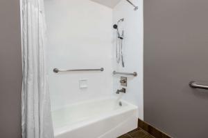 a bathroom with a white tub and a shower at Hotel 1550 - SFO Airport FREE Shuttle in San Bruno +16 photos