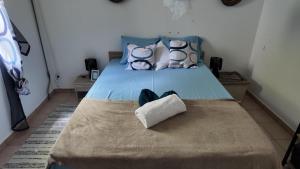 a bed with a blue bedspread and pillows at Ti kaz a fredo in Port-Louis