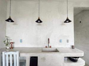 a kitchen with a sink and three pendant lights at Casa Lai in Mazunte
