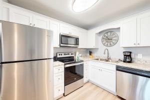 a kitchen with white cabinets and a stainless steel refrigerator at Plantation East #4113 in Fort Morgan +43 photos