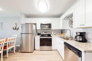 a kitchen with white cabinets and a stainless steel refrigerator at Plantation East #4113 in Fort Morgan
