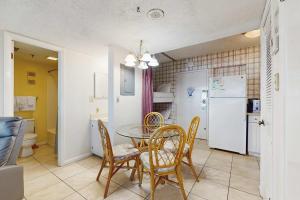 a dining room with a table and chairs and a refrigerator at Contemporary beachside escape with gym & pools in Fort Morgan