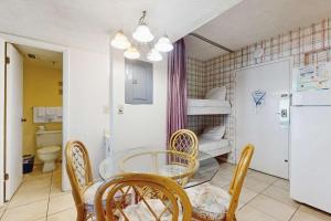 a dining room with a table and chairs and a bunk bed at Contemporary beachside escape with gym & pools in Fort Morgan