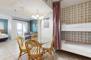 a room with a table and chairs and a bunk bed at Contemporary beachside escape with gym & pools in Fort Morgan +20 photos