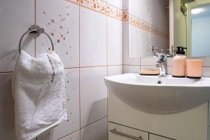 a white bathroom with a sink and a mirror at Apartments Mistral in Lopar +55 photos