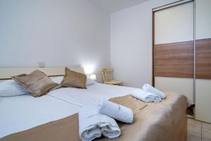 a bedroom with two white towels on a bed at Apartments Mistral in Lopar