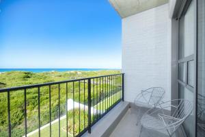 a balcony with two chairs and a view of the ocean at Sonvanger Villa Struisbaai in Struisbaai