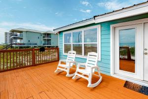 two white chairs sitting on the deck of a house at Fine Fish House in Gulf Highlands