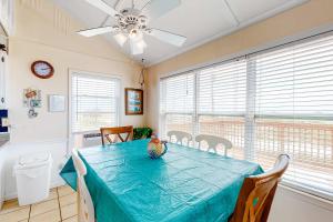 a dining room with a blue table and a ceiling fan at Fine Fish House in Gulf Highlands