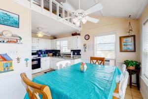 a dining room with a table and a kitchen at Fine Fish House in Gulf Highlands +21 photos