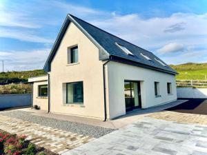 a small white house with a black roof at The Summit - Skellig Coast in Cahersiveen