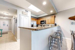 a kitchen with a counter and some stools in it at The Indies #503 in Fort Morgan