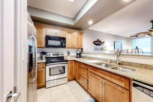 a kitchen with wooden cabinets and stainless steel appliances at The Indies #503 in Fort Morgan