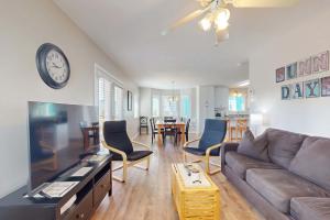 a living room with a couch and a clock on the wall at Gulf view duplex with multi-level balcony hot tub in Fort Morgan