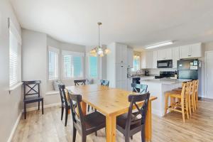 a kitchen and dining room with a wooden table and chairs at Gulf view duplex with multi-level balcony hot tub in Fort Morgan +31 photos