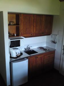 a kitchen with a sink and a stove and cabinets at Manantiales Club de Mar in Mar del Plata