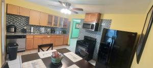 a kitchen with a table and a black refrigerator at Great location to explore Houston in Houston