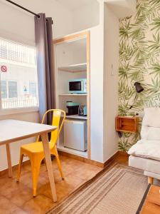 a living room with a table and a yellow chair at Nanit Rooms Ibiza Hostal in Santa Eularia des Riu