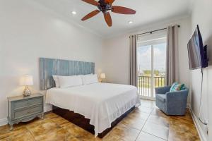 a bedroom with a bed and a ceiling fan at Beachfront dog-friendly home with private pool sundeck and elevator in Fort Morgan