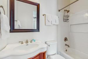a bathroom with a sink and a toilet and a mirror at Beachfront dog-friendly home with private pool sundeck and elevator in Fort Morgan +27 photos