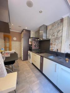 a large kitchen with a sink and a stove at Encanto Histórico 9 in Avilés