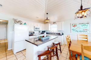 a kitchen with white appliances and a wooden table at Blue Marlin in Gulf Shores