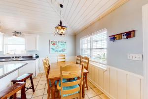 a kitchen and dining room with a wooden table and chairs at Blue Marlin in Gulf Shores