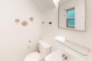 a white bathroom with a toilet and a mirror at Campbellot by Meyer Vacation Rentals in Fort Morgan +14 photos