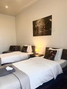 ein Zimmer mit drei Betten und einem Gemälde an der Wand in der Unterkunft Vabriku 6 Apartment with sauna in Rakvere + 36 Fotos