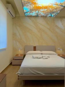 a bedroom with a bed with two towels on it at Ludogà Luxury Suite in Trebisacce +21 photos