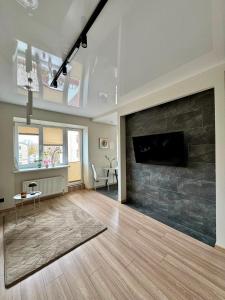a living room with a stone fireplace and a table at Sandstone Residence - Modern Apartment - 5 min Walk to Beach in Liepāja