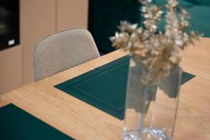 a vase of flowers on a table with a chair at Grand Panorama Residence in Mamaia