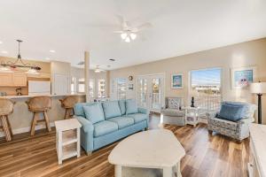 a living room with a blue couch and a kitchen at Beach Haven by Meyer Vacation Rentals in Gulf Shores
