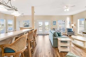 a living room with a bar and chairs at Beach Haven by Meyer Vacation Rentals in Gulf Shores