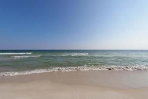 an empty beach with the ocean in the background at Beautiful condo with shared pools full kitchen private washer dryer in Gulf Shores