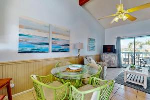 a dining room with a glass table and chairs at Beautiful condo with shared pools full kitchen private washer dryer in Gulf Shores
