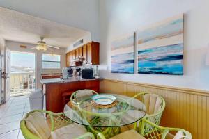 a kitchen with a glass table and chairs at Beautiful condo with shared pools full kitchen private washer dryer in Gulf Shores