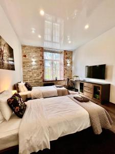 ein Schlafzimmer mit zwei Betten und einem Flachbildfernseher in der Unterkunft Vabriku 6 Apartment with sauna in Rakvere