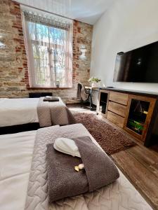 ein Hotelzimmer mit zwei Betten und einem Flachbildfernseher in der Unterkunft Vabriku 6 Apartment with sauna in Rakvere