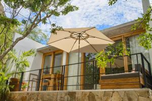 a house with an umbrella in front of it at El Guayacan in Zipolite