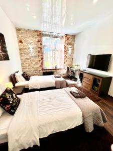 ein Hotelzimmer mit zwei Betten und einem Flachbildfernseher in der Unterkunft Vabriku 6 Apartment with sauna in Rakvere