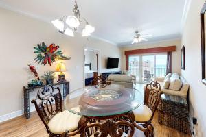 a dining room with a glass table and chairs at Crystal Tower 705 in Gulf Shores