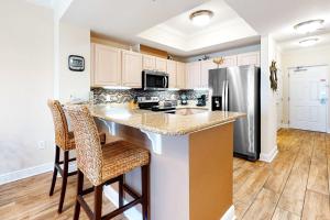 a kitchen with a counter and a refrigerator at Crystal Tower 705 in Gulf Shores +29 photos